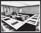Photographs of workers assembling desks inside a classroom in Joyner Library